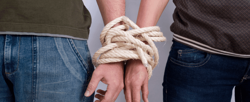 two people with their wrists joined together to symbolise codependency